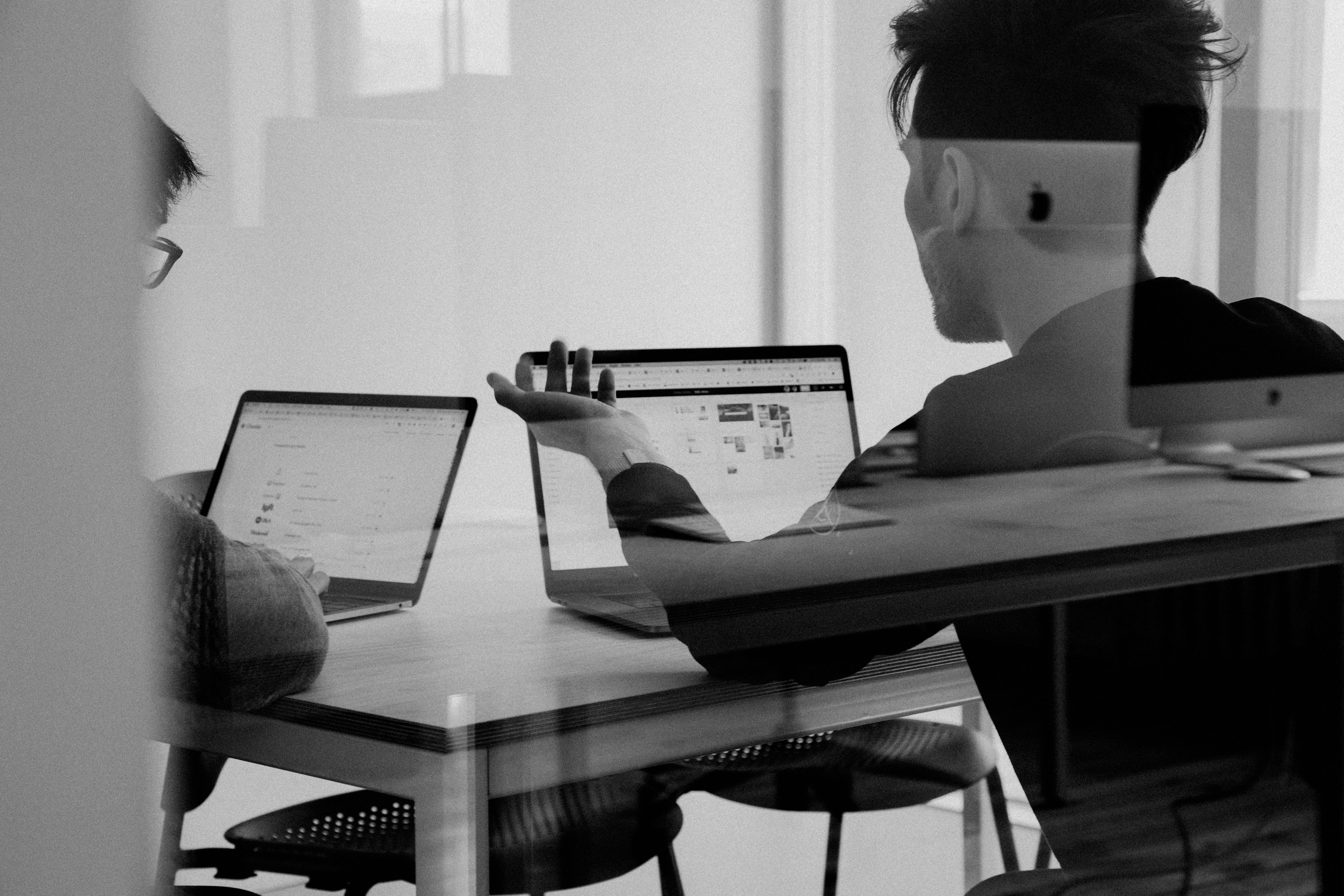 Colleagues discussing a digital product at a shared workspace